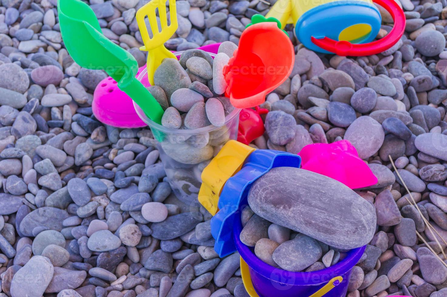 colorful children toys on pebble beach. Leisure and vacation concept photo