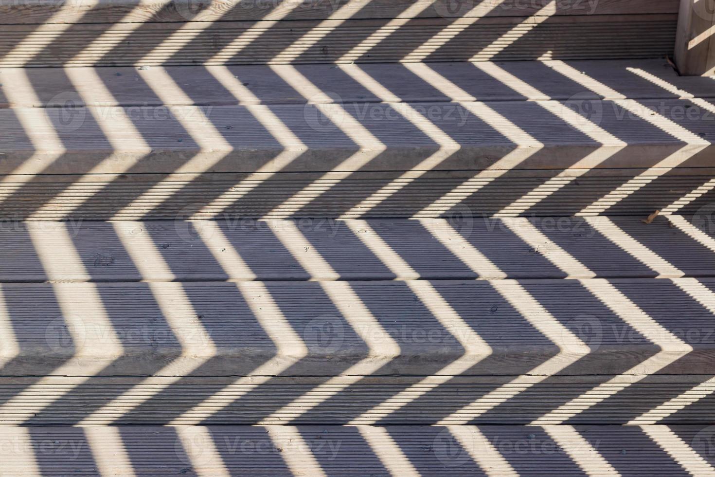 Abstract background texure of hard shadows of wooden bridge railings photo