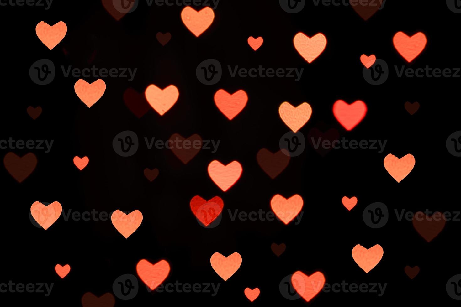Pink hearts bokeh on black background. Festive Texture for holidays photo