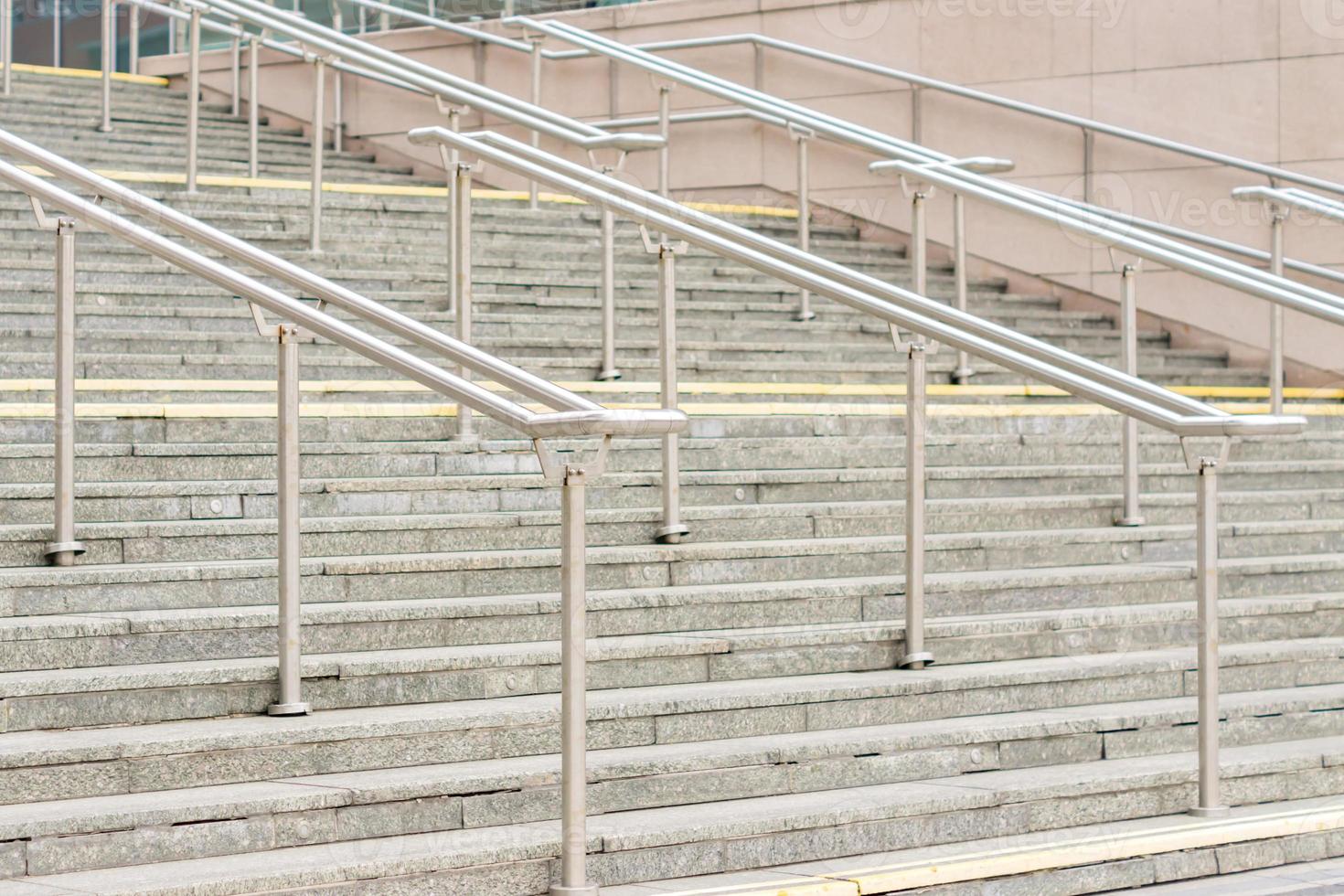 view to outdoor steps with metal railing in center of leading to entrance into modern building photo