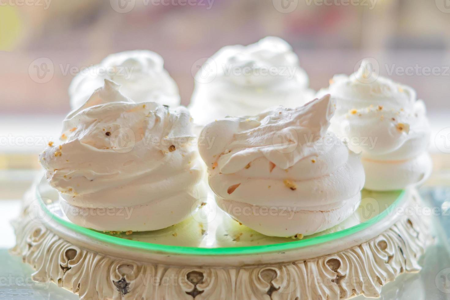 white air meringues on display plate at pastry shop photo