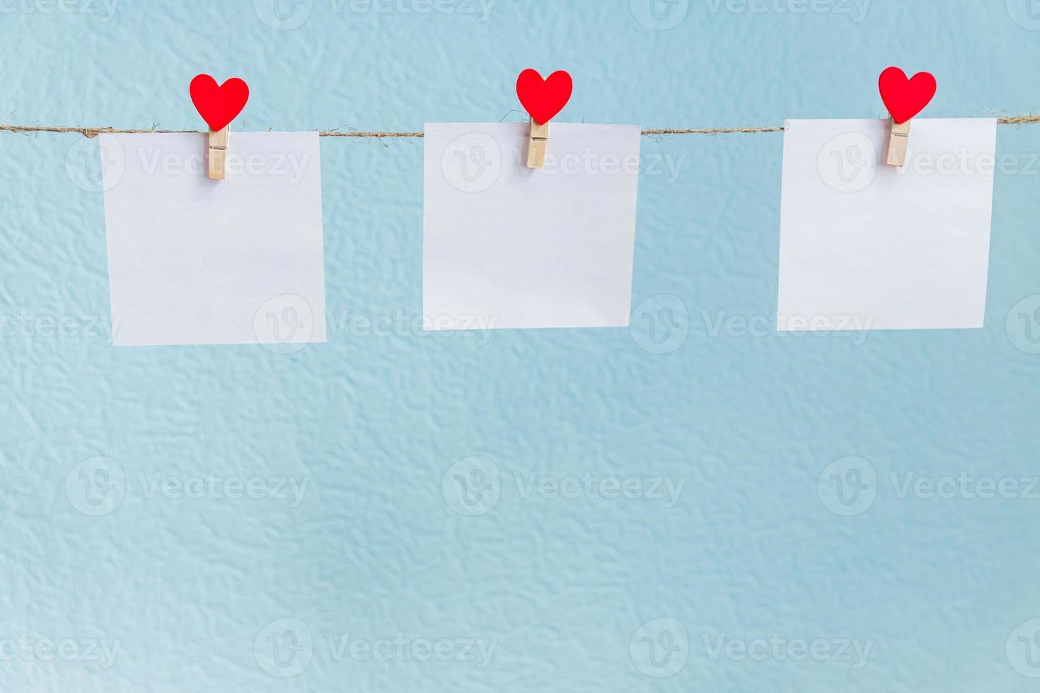 Red Valentine's love hearts pins hanging on natural cord against blue background. Mock up concept for your text photo