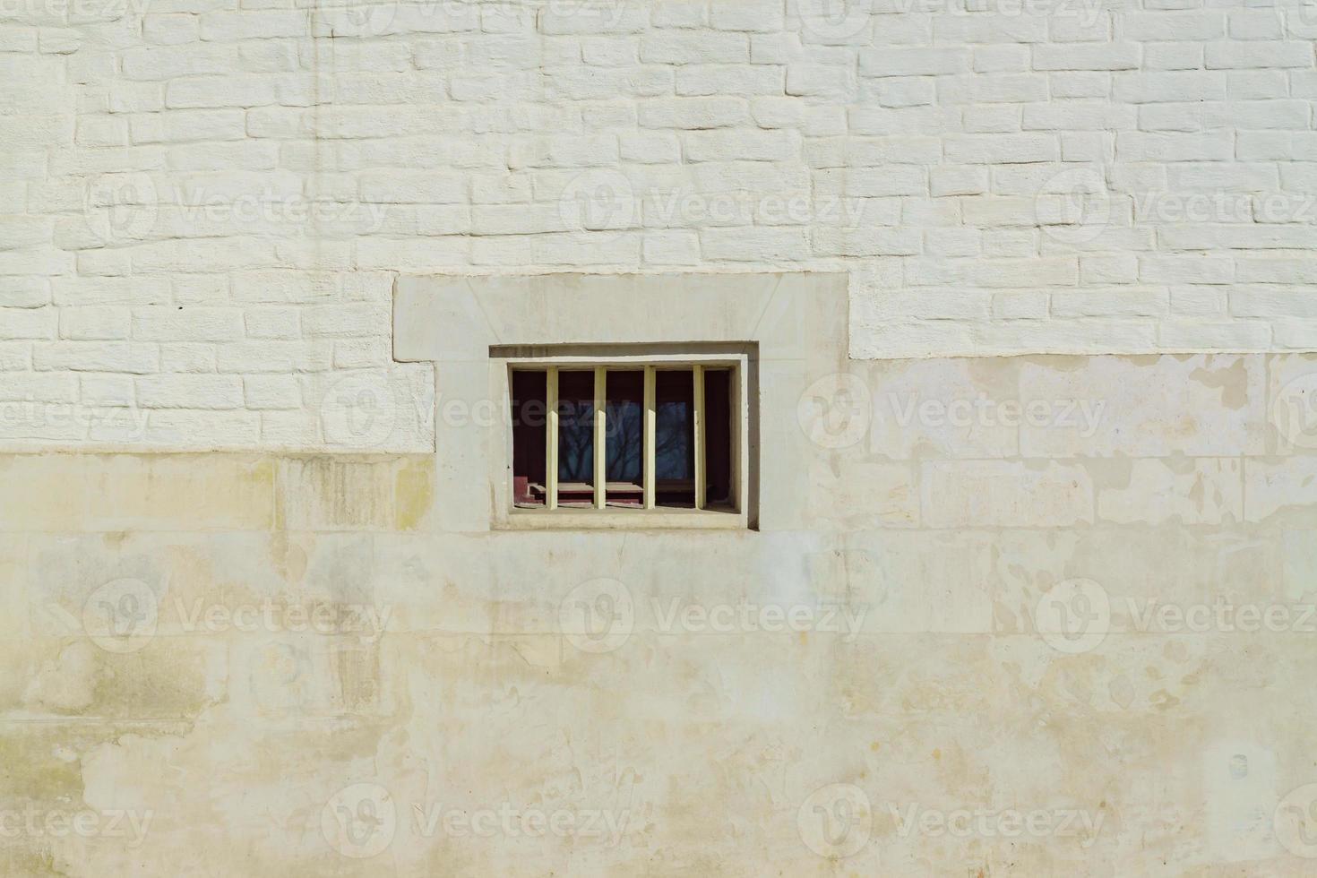White brick wall and small window in the middle. Backgound texture photo