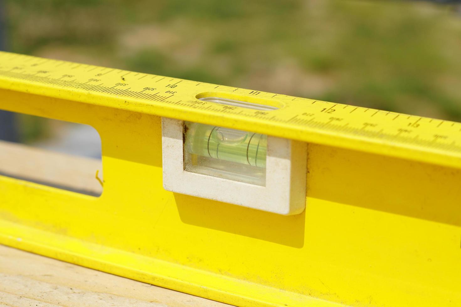 Yellow building level . working tool on wooden background photo