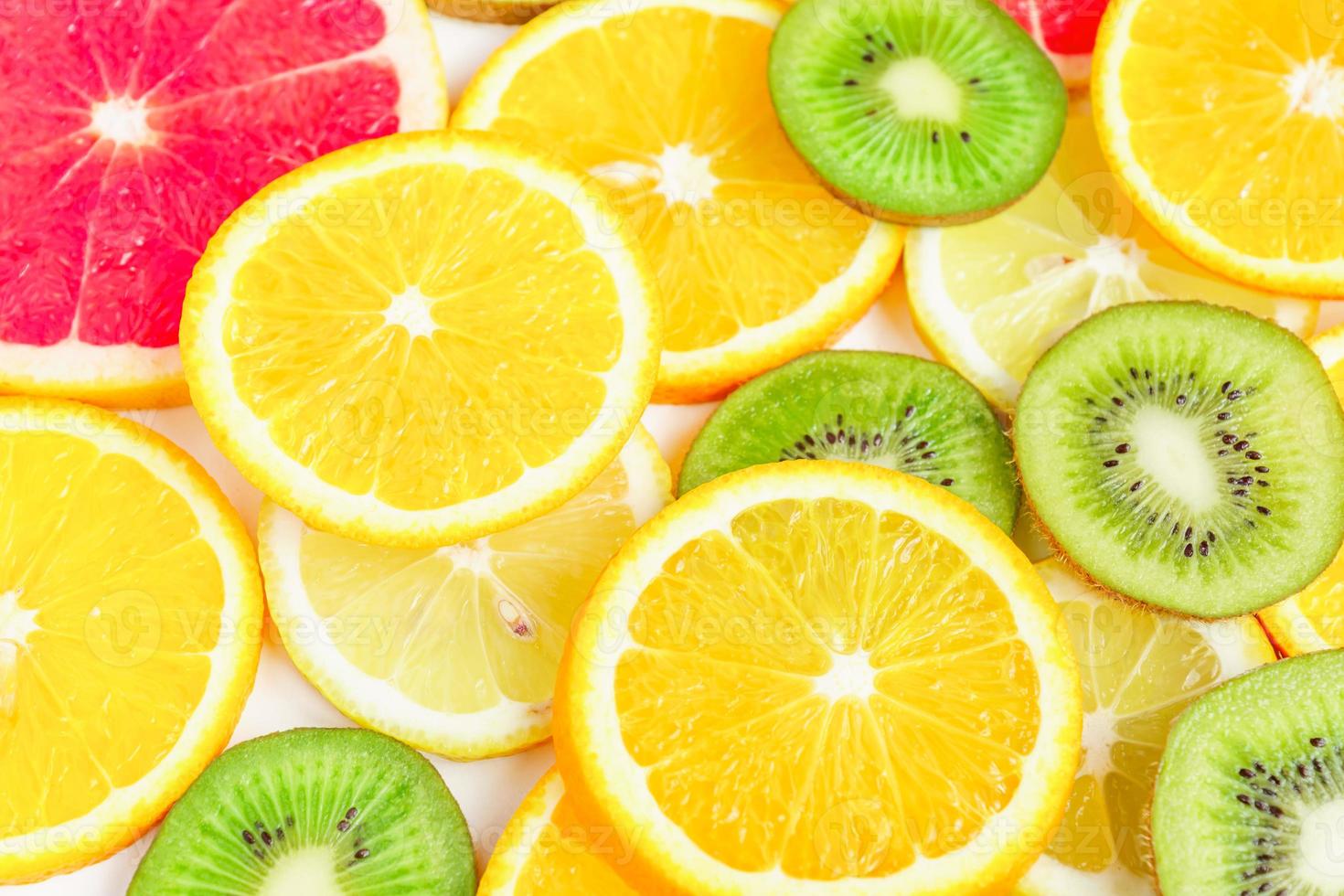 citrus slices - kiwi, oranges and grapefruits on white background. Fruits backdrop photo