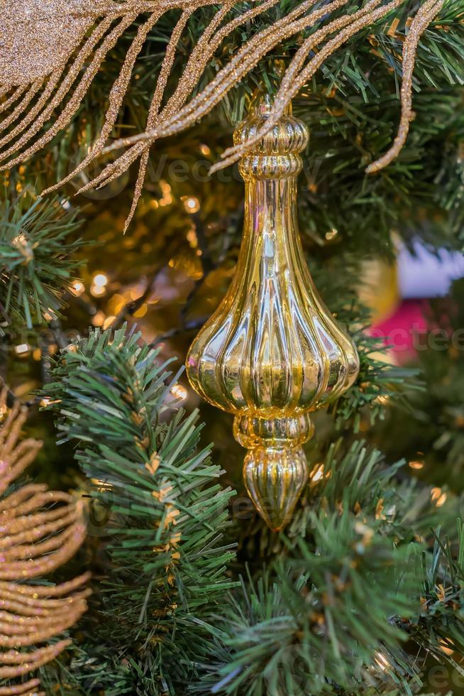 Christmas and New Year holidays background. Christmas tree decorated with gold  toy and sparkling feather. Celebration concept photo