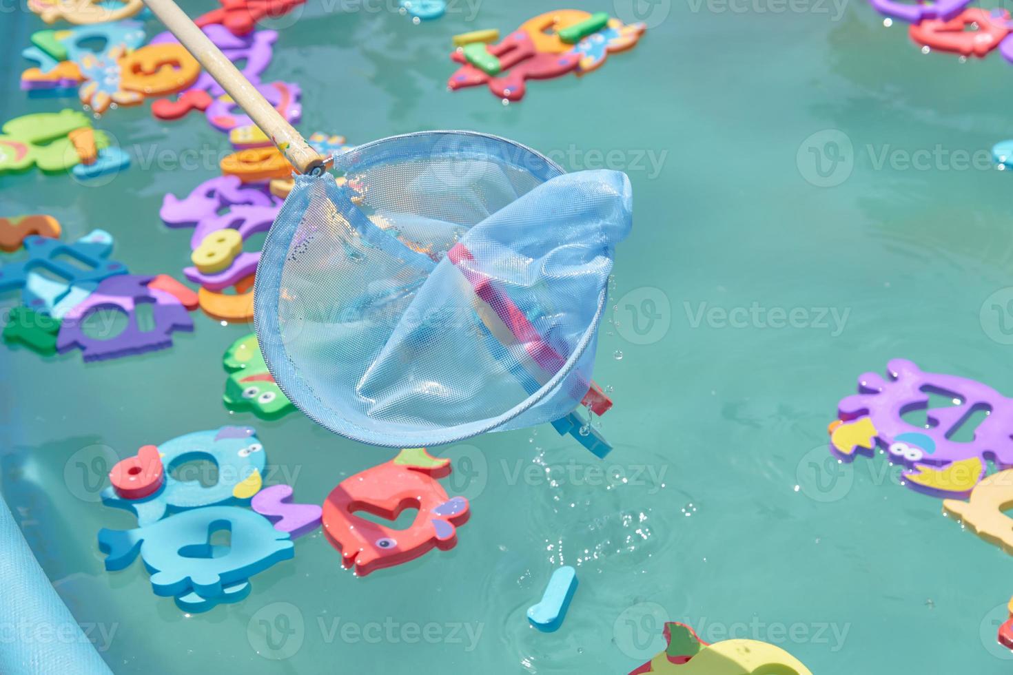 primer plano de figuras de animales marinos de colores flotantes en la piscina para atrapar una red. entretenimiento para niños foto