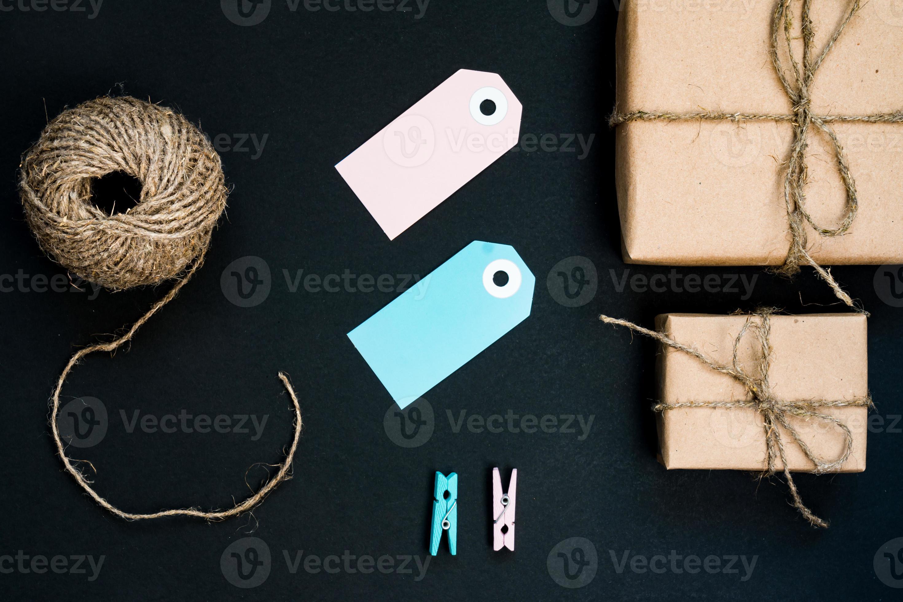 Handcrafted gift boxes wrapped in Craft paper with blue paper card tag, rope  and wooden clothespins for decoration. 10607429 Stock Photo at Vecteezy