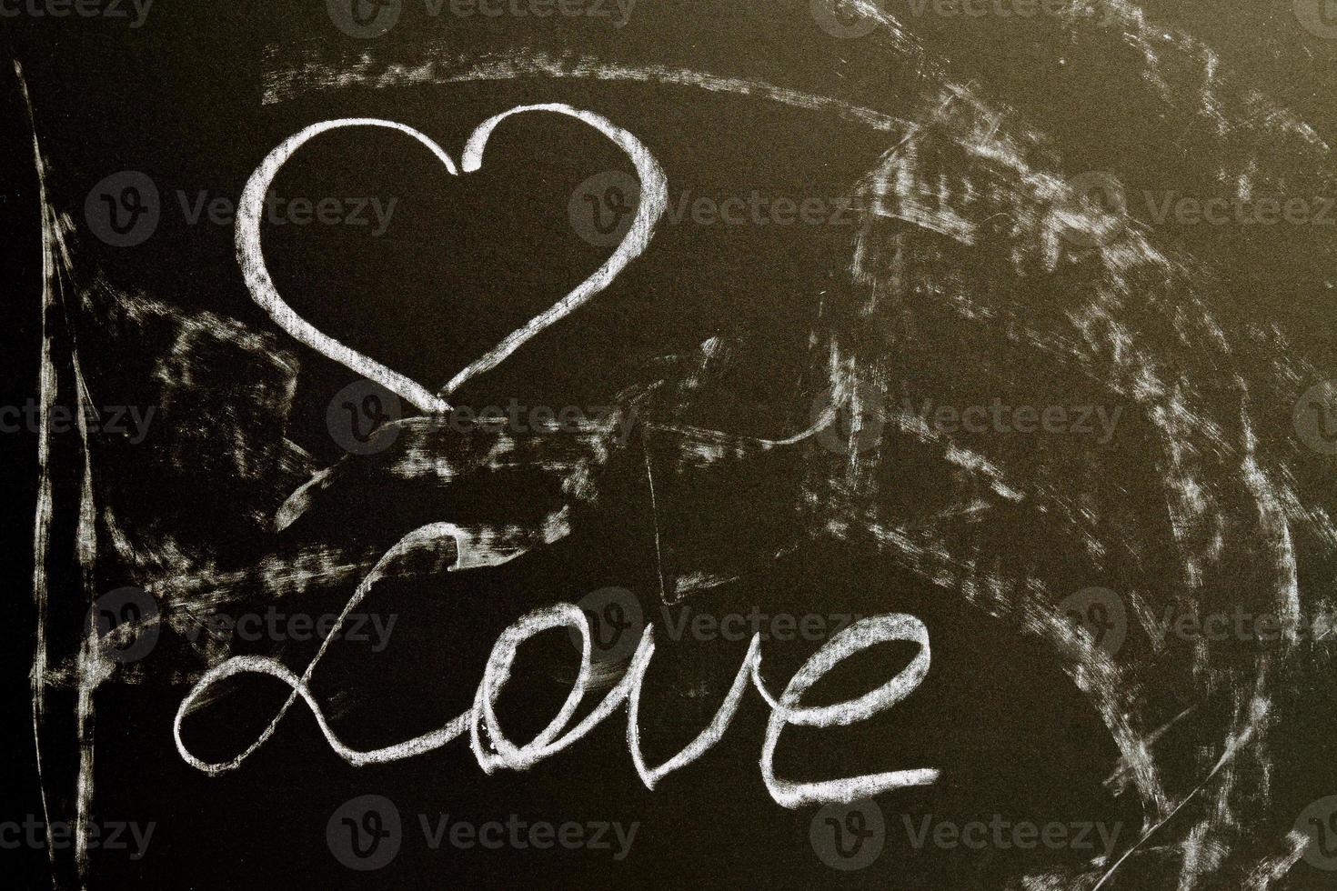 A chalk board with the word love and a heart. Grunge background texture photo
