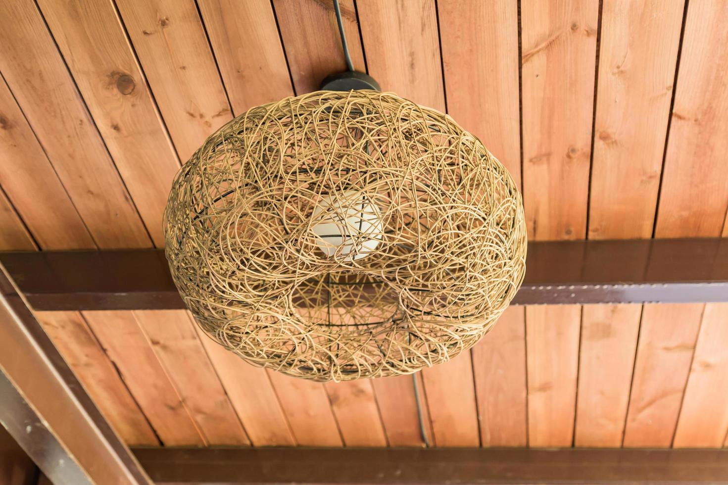 chandelier made of straws on wooden ceiling photo