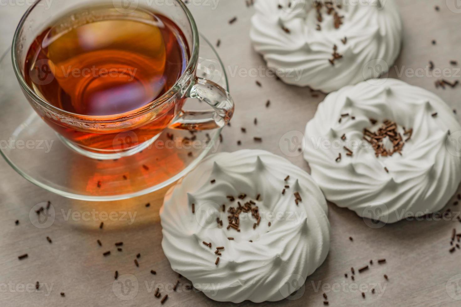 black tea in transparent cup an air homemade meringues close up photo