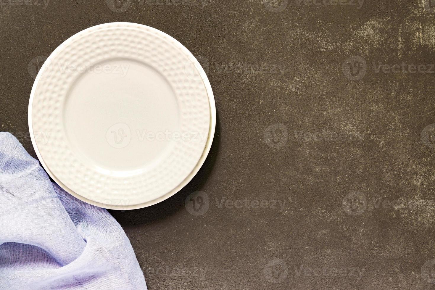 Top view of empty served plate, gray textile napkin on black concrete background. Copy space. photo
