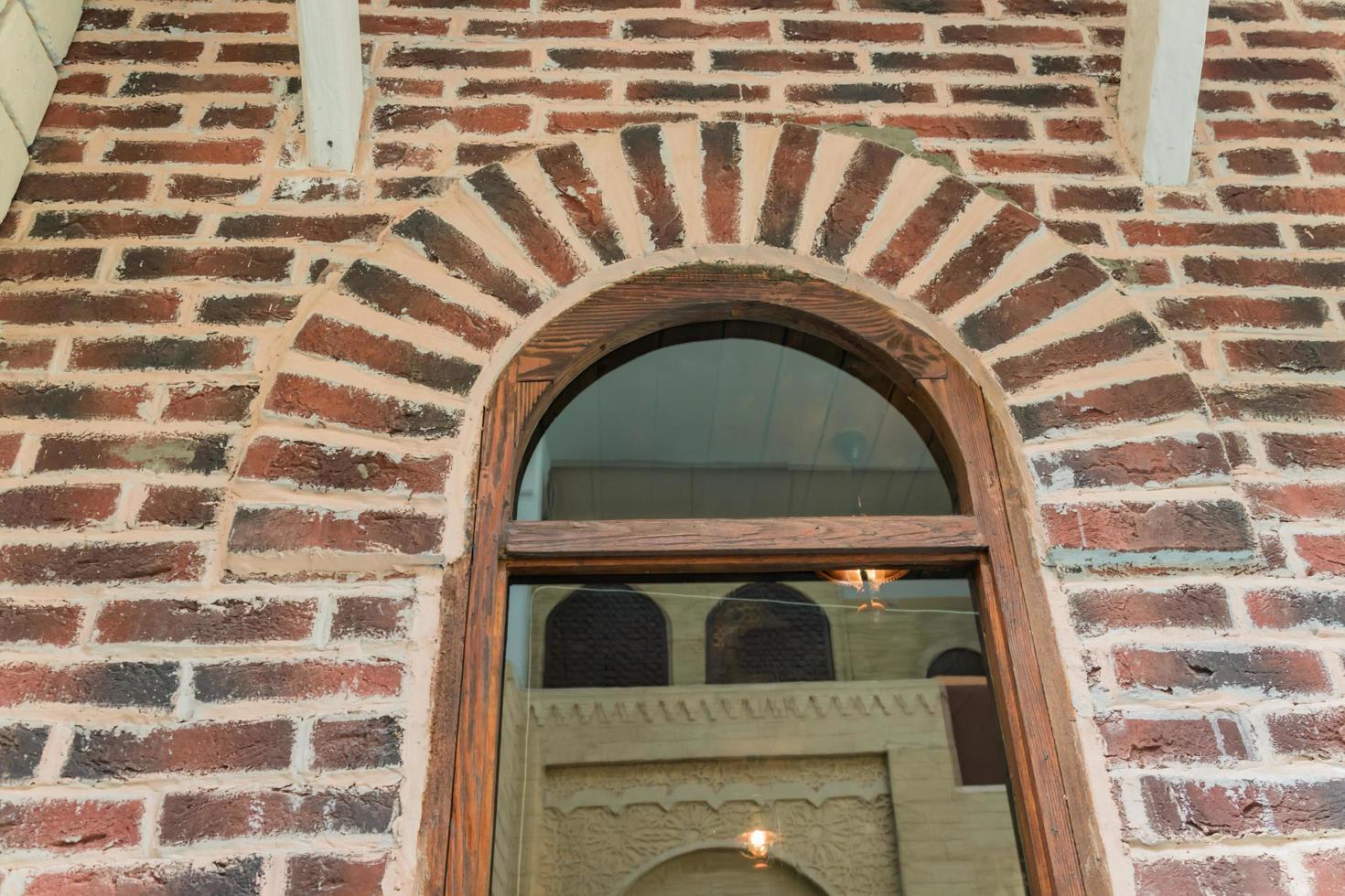 close up of brick wall and big window with reflection photo