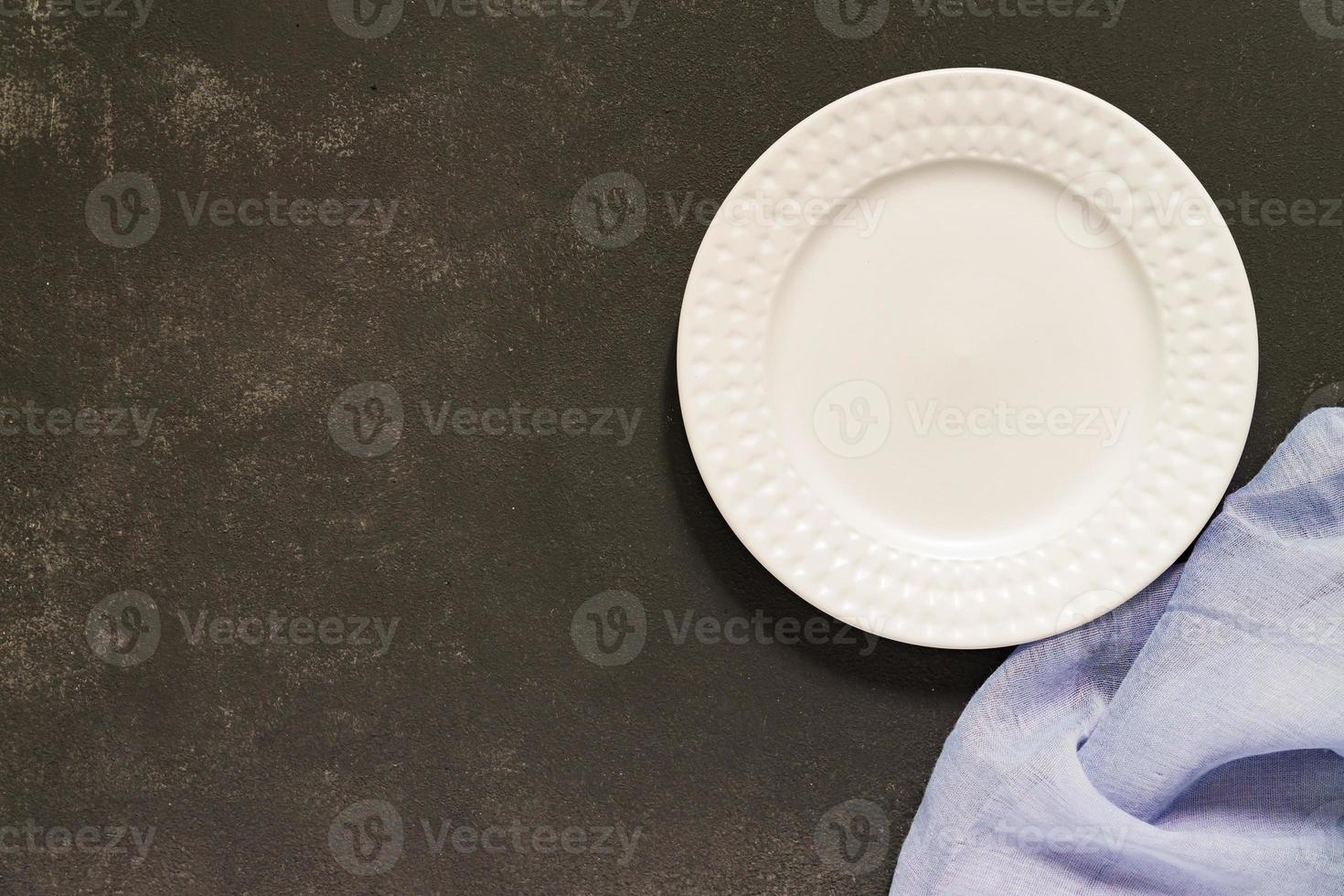 Top view of empty served plate, gray textile napkin on black concrete background. Copy space. photo