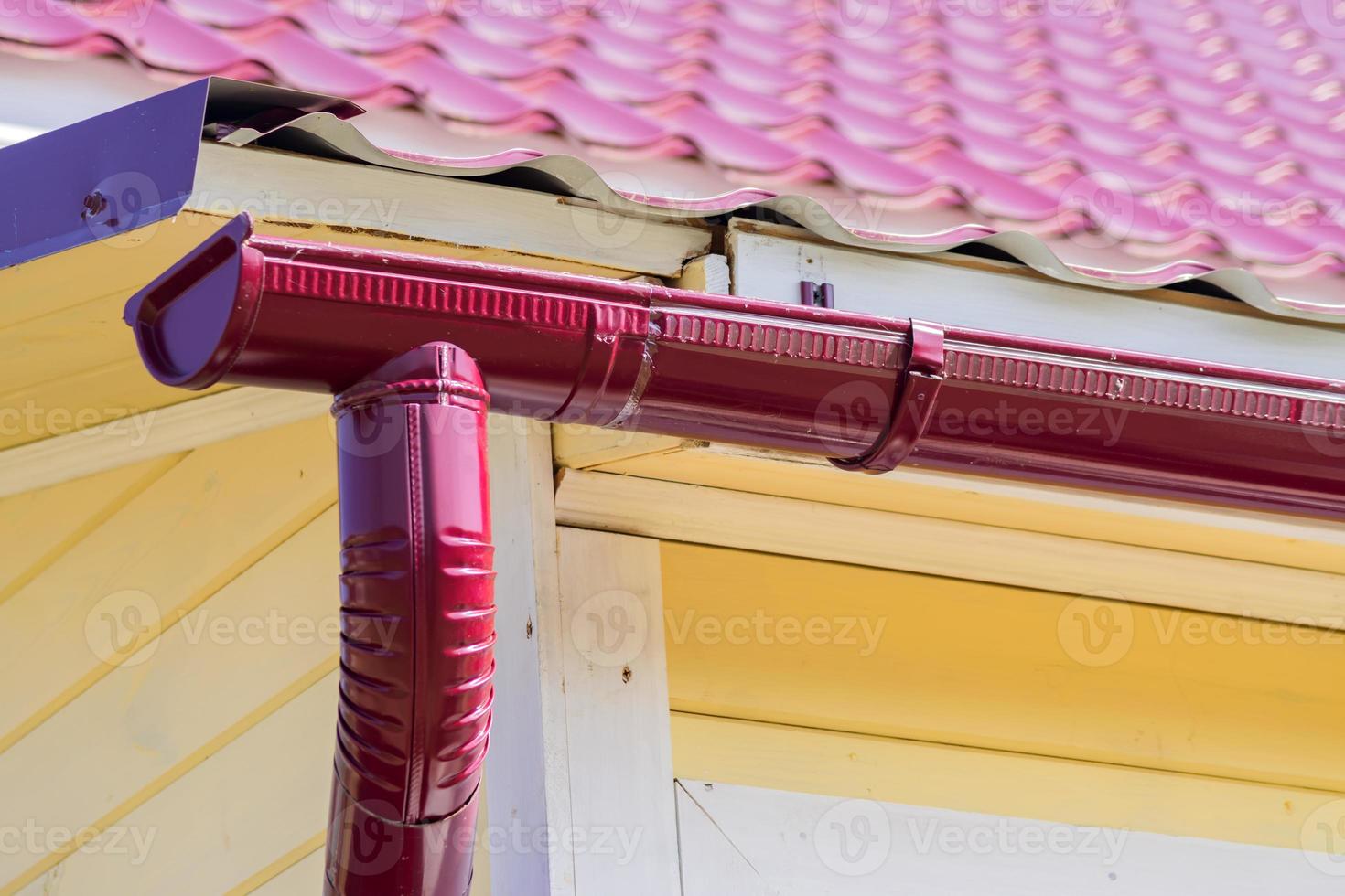 red gutter on the roof top of house photo