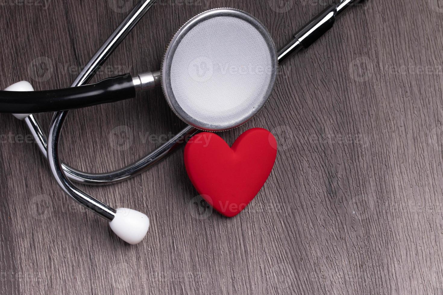 Stethoscope with red heart on gray background. Heart health care concept. photo