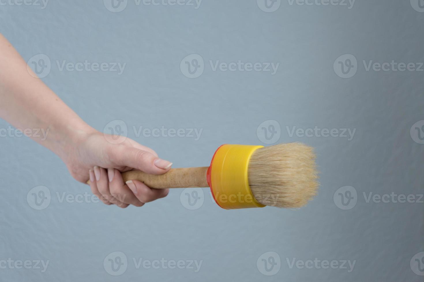 mujer sosteniendo un gran pincel en la mano para hacer reparaciones. foto