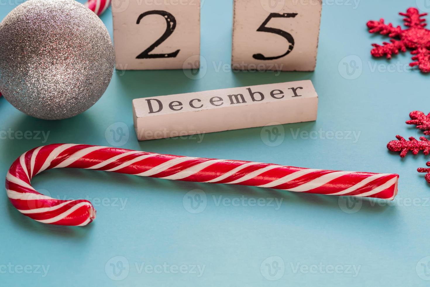 calendario de bloques de madera que muestra el 25 de diciembre. Navidad. tarjeta de felicitación con bastones de caramelo y copos de nieve brillantes. foto