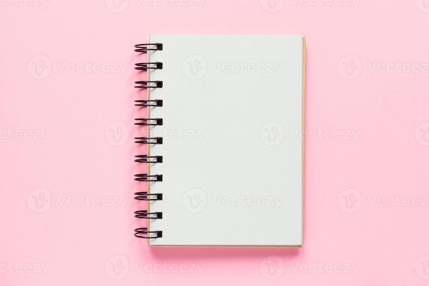 Top view of open empty notebook on pastel pink colorful background photo