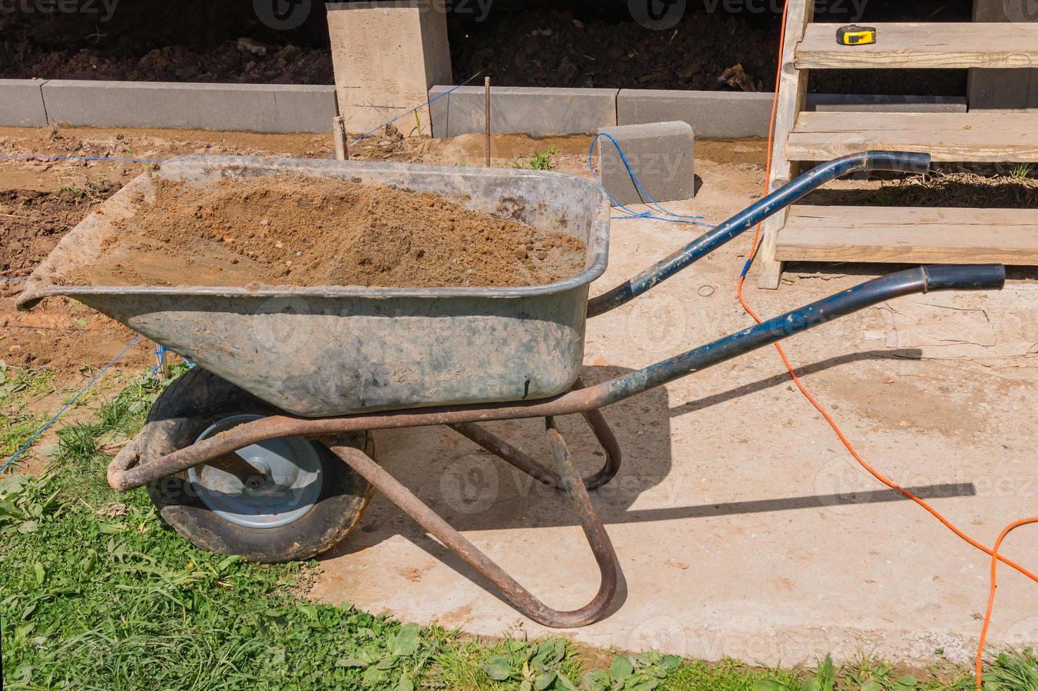 construction site with wheel barrow with sand. photo