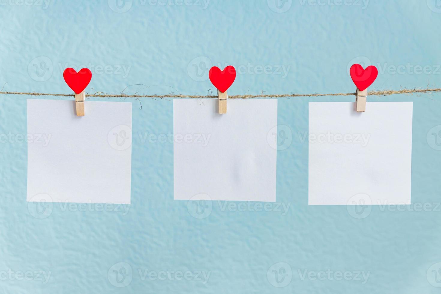 Blank cards on pins with red hearts. Mockup for text and blue background for Valentines Day greetings photo