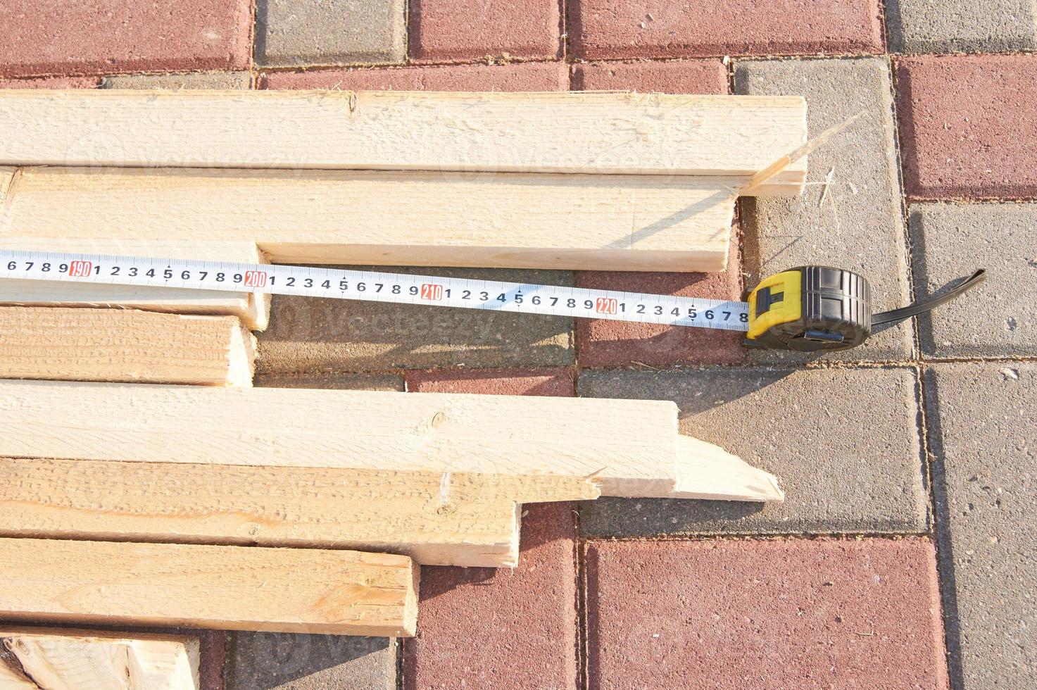 Worker measures wooden beams on the tile floor Construction works photo