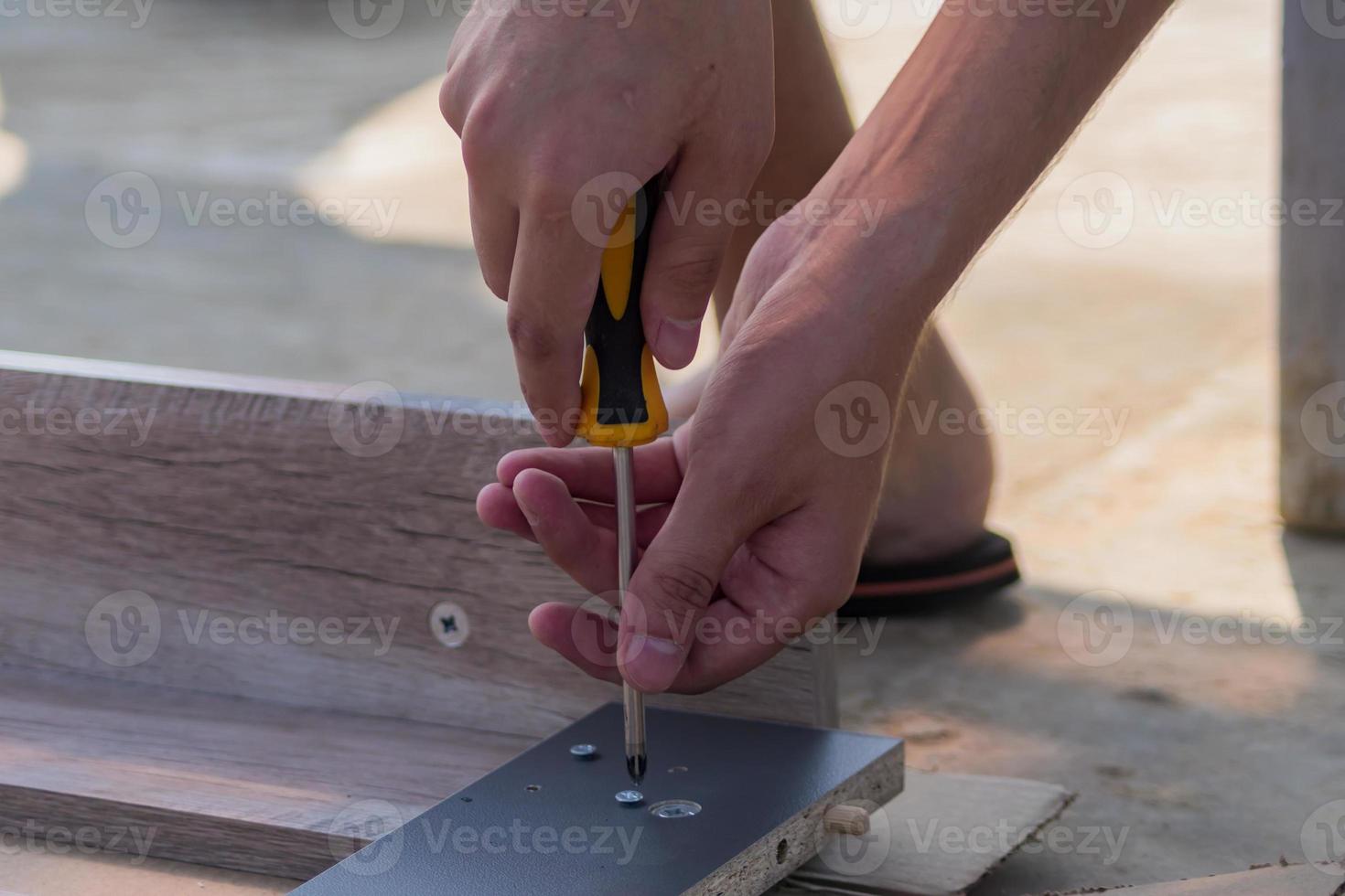furniture assembling - Carpentry screws for a knock down wooden table. photo