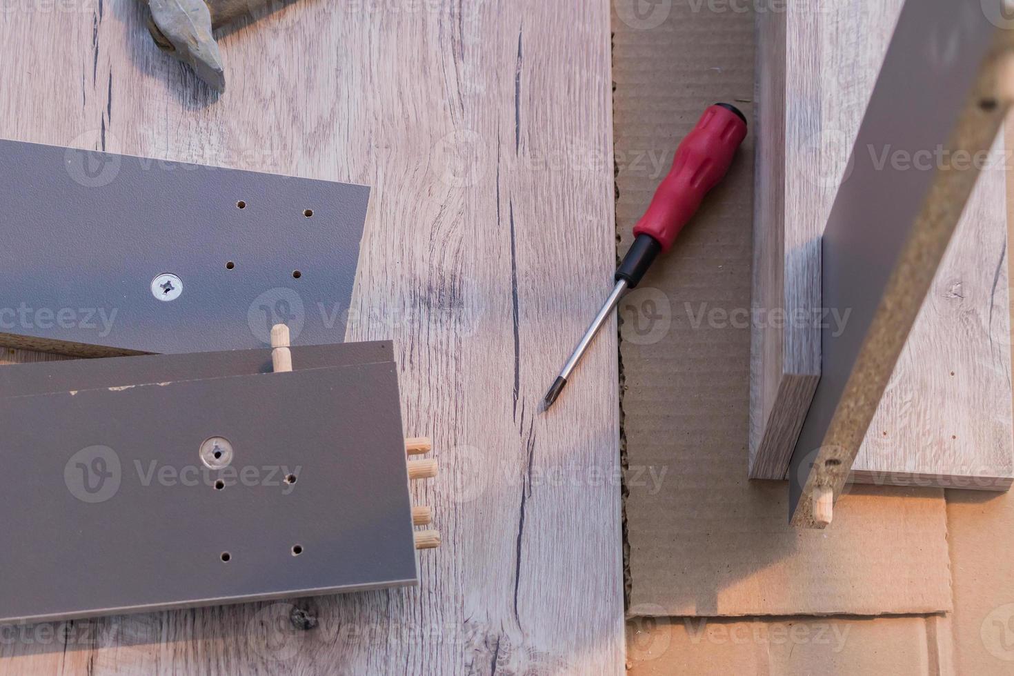 furniture assembling - screwdriver and table parts on the floor photo
