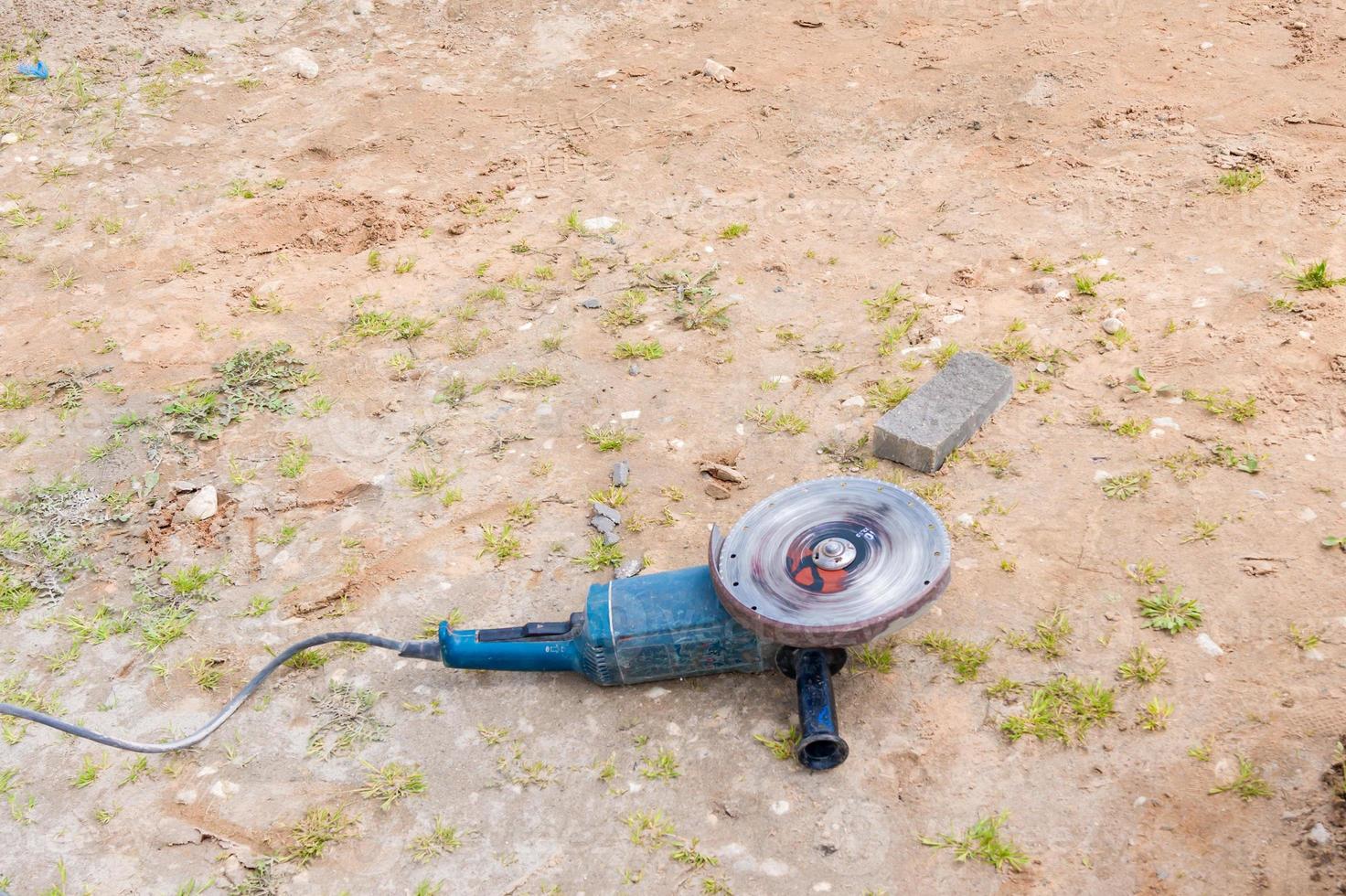 operating angle grinder on the ground. photo