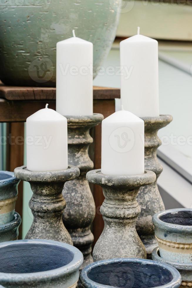 Handmade ceramic candle sticks with big candles in decor shop. photo