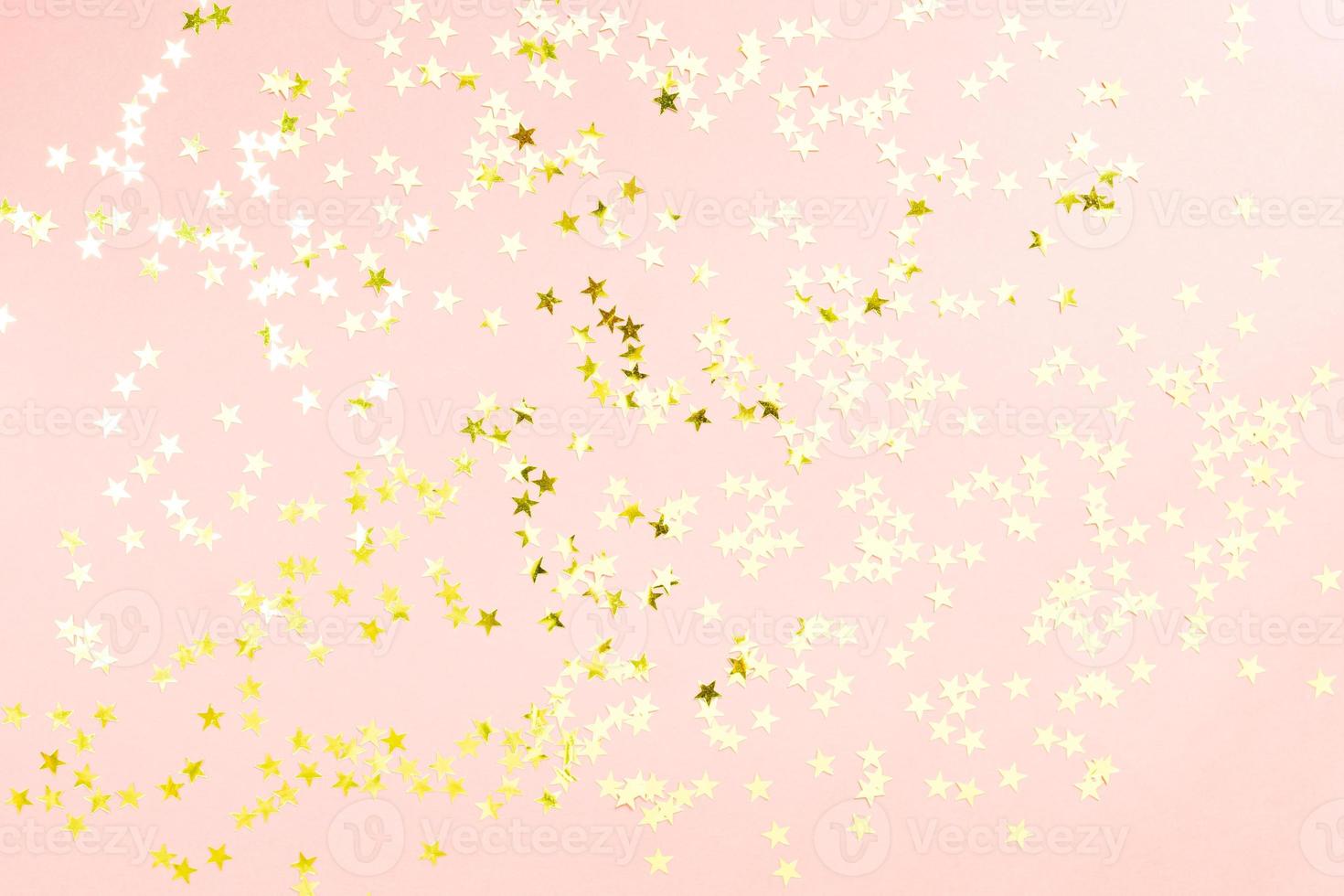 Holographic stars and gold sparkles on pastel pink background. Festive backdrop for your projects photo