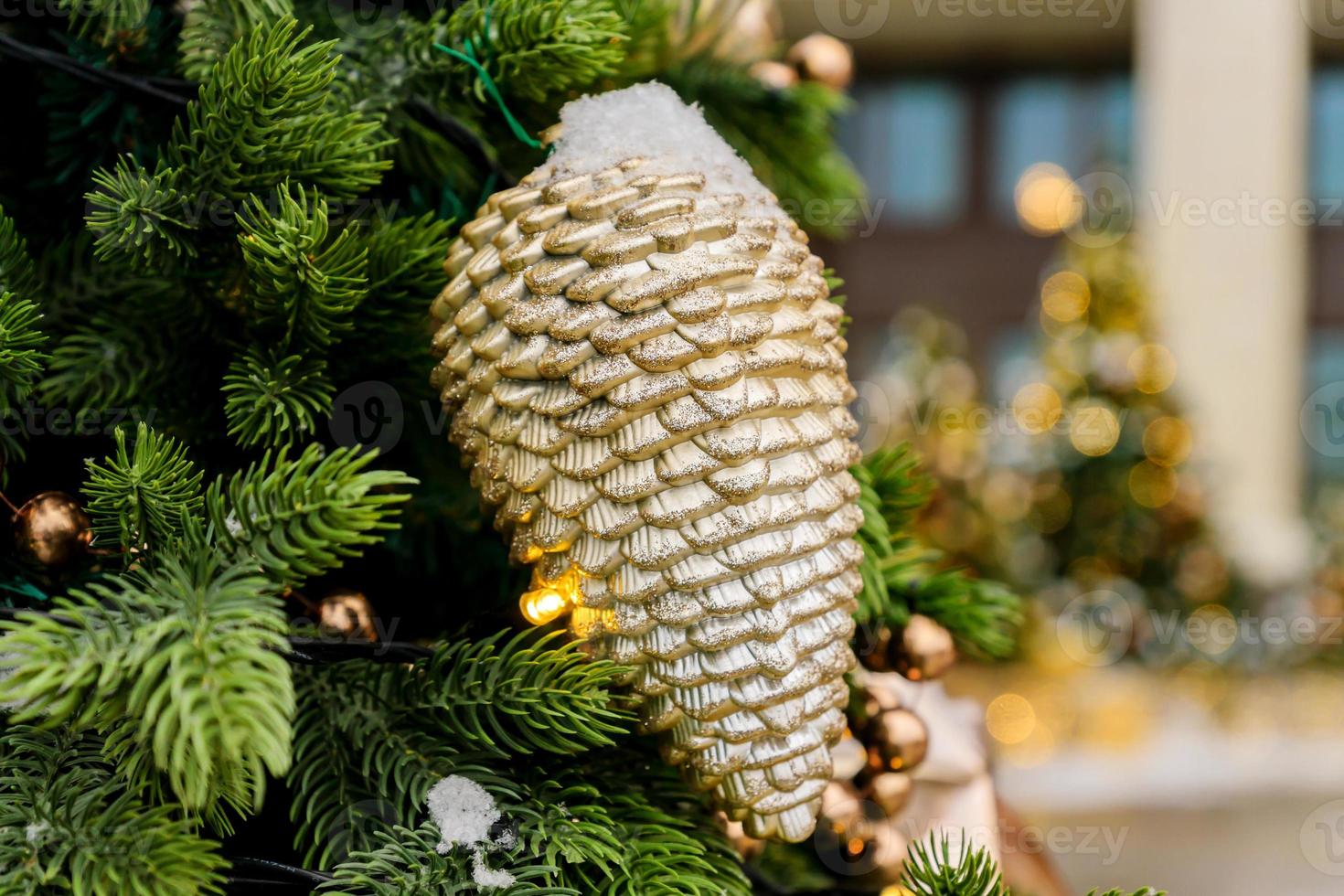 close up of christmas trees decorated with sparkling cones and garland with lights on. Festive background with copy space for your projects photo