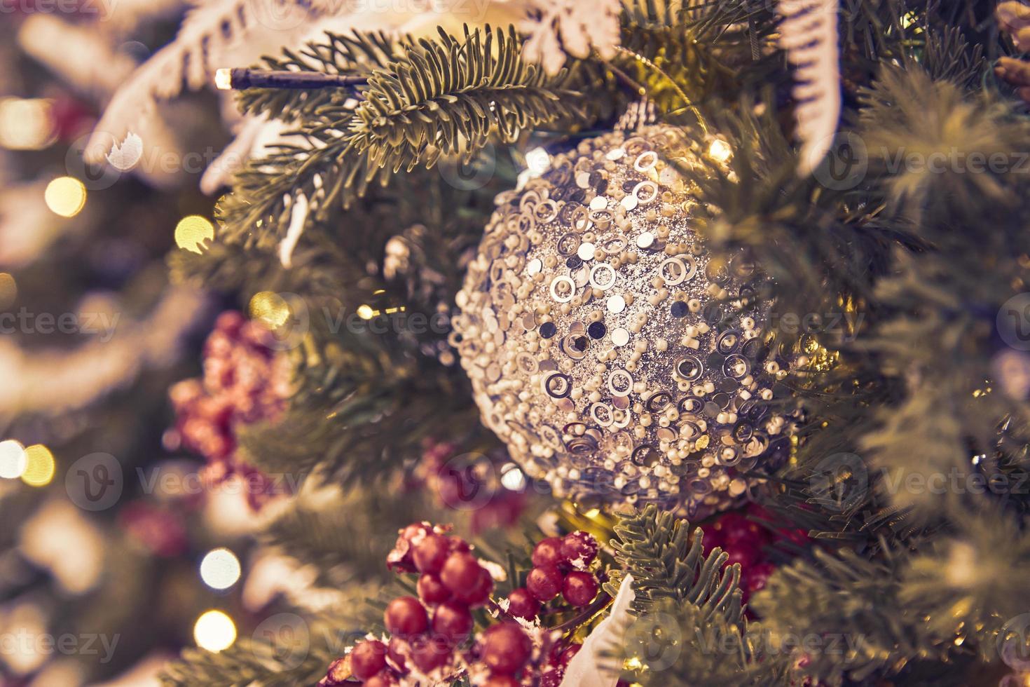close up of christmas tree decorated with silferr sparkling balls and garland with lights on. Festive background with copy space for your projects photo