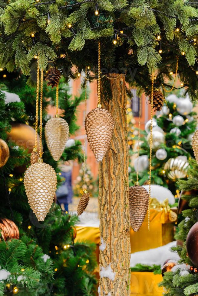 close up of christmas trees decorated with sparkling cones and garland with lights on. Festive background with copy space for your projects photo