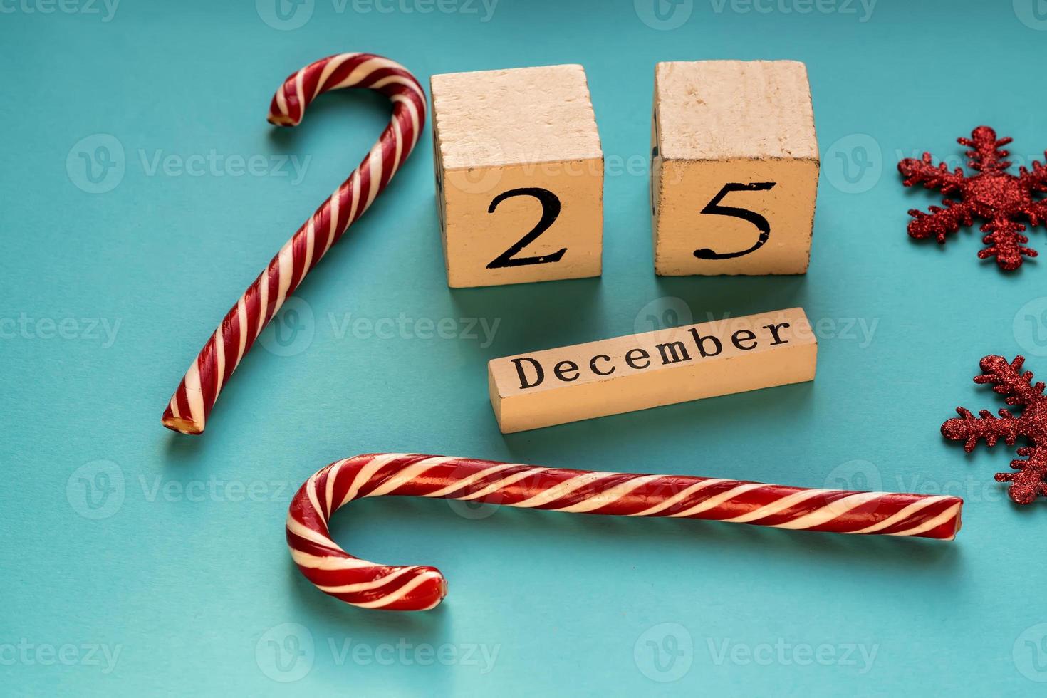 Wooden block calendar showing 25th of December. Christmas holiday. Greeting card with candy canes and sparkling snowflakes. photo