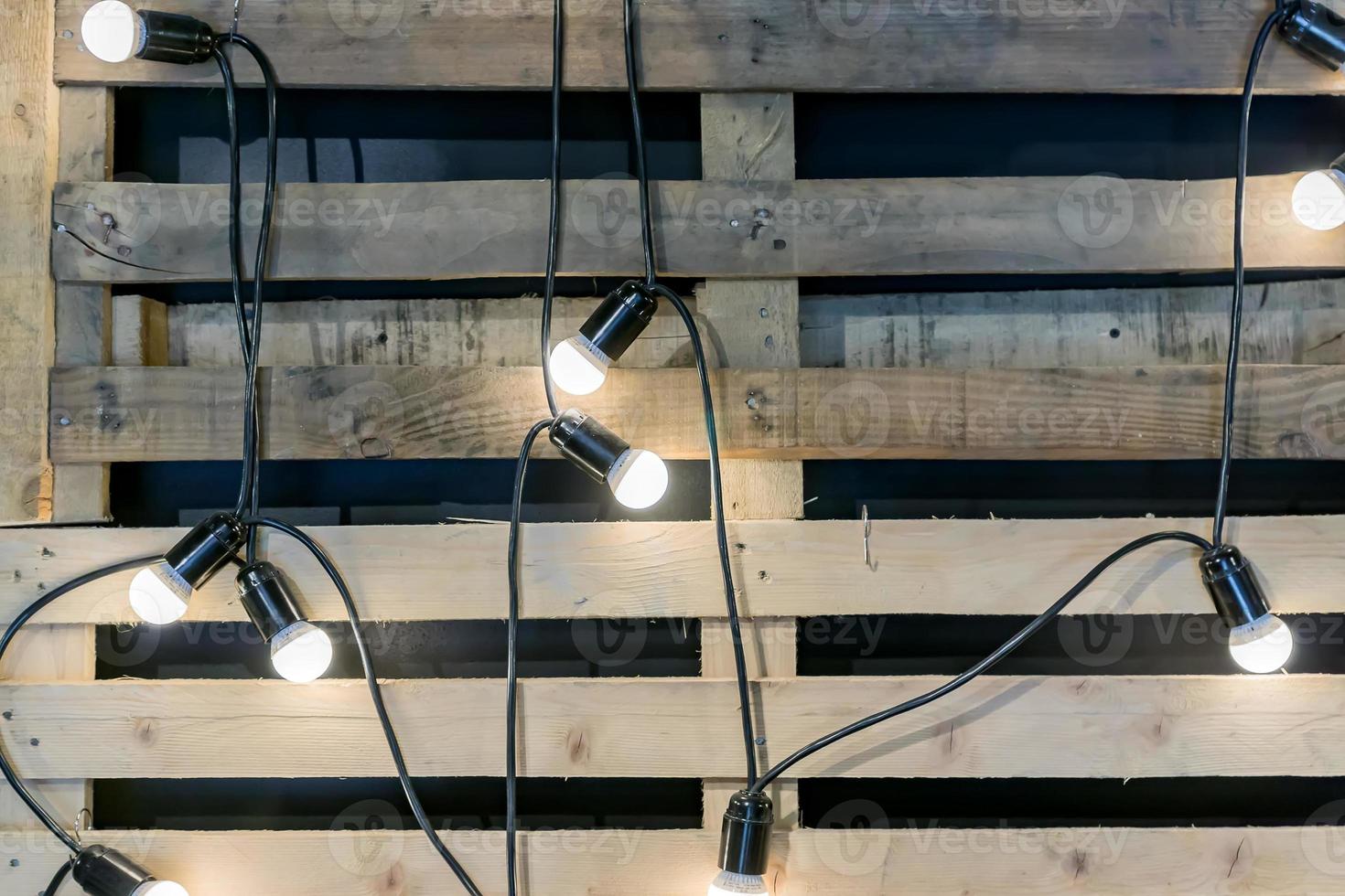 Loft style background. Garland with bulbs and wooden pallet on the wall photo