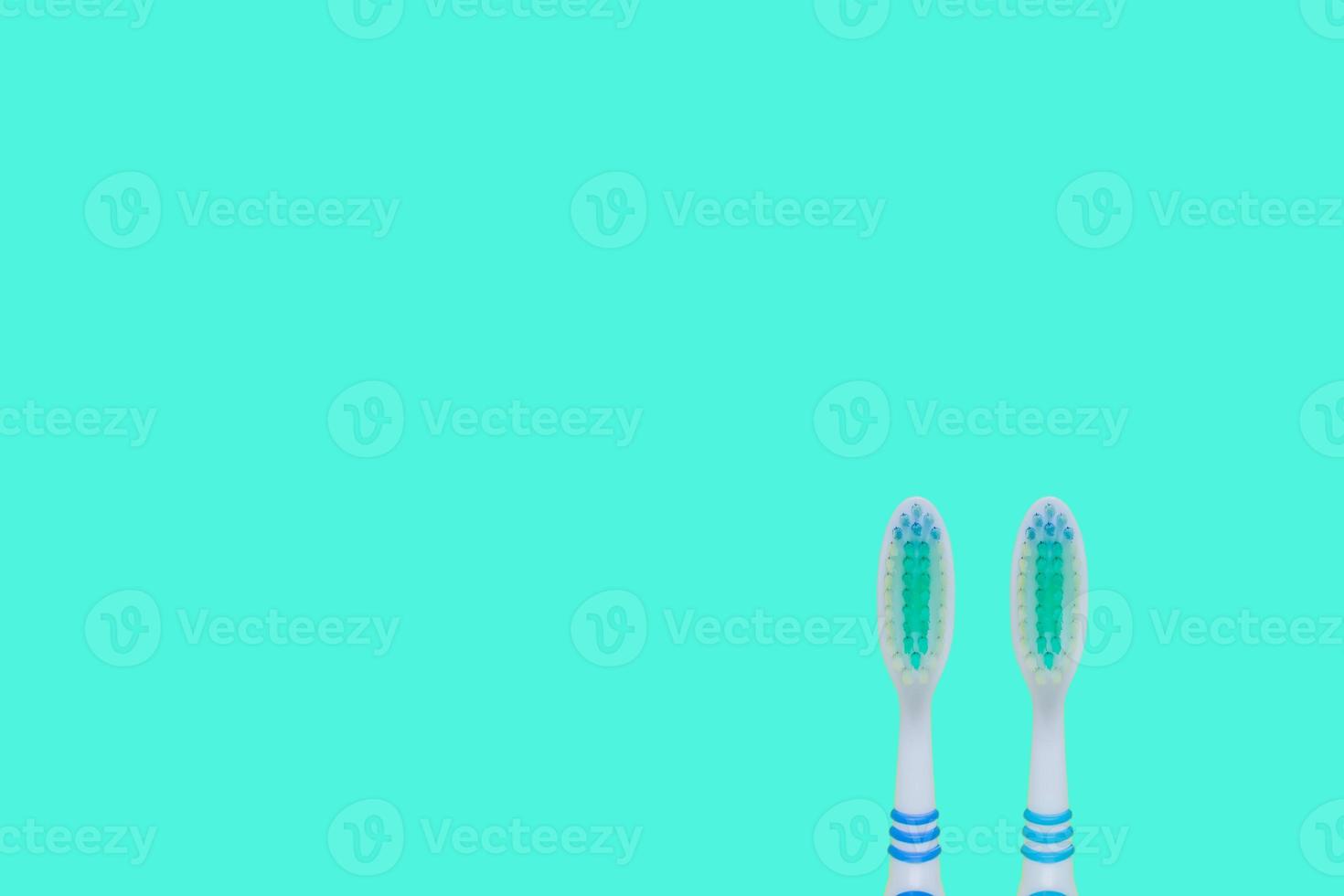 Two toothbrushes  on blue background. Top view, minimal flat lay. photo