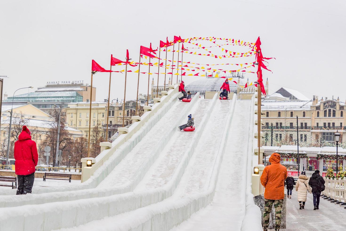 Moscow, Russia, 2018 -  Race sledding at the Manege square.  happy children sliding down on snow tubes photo