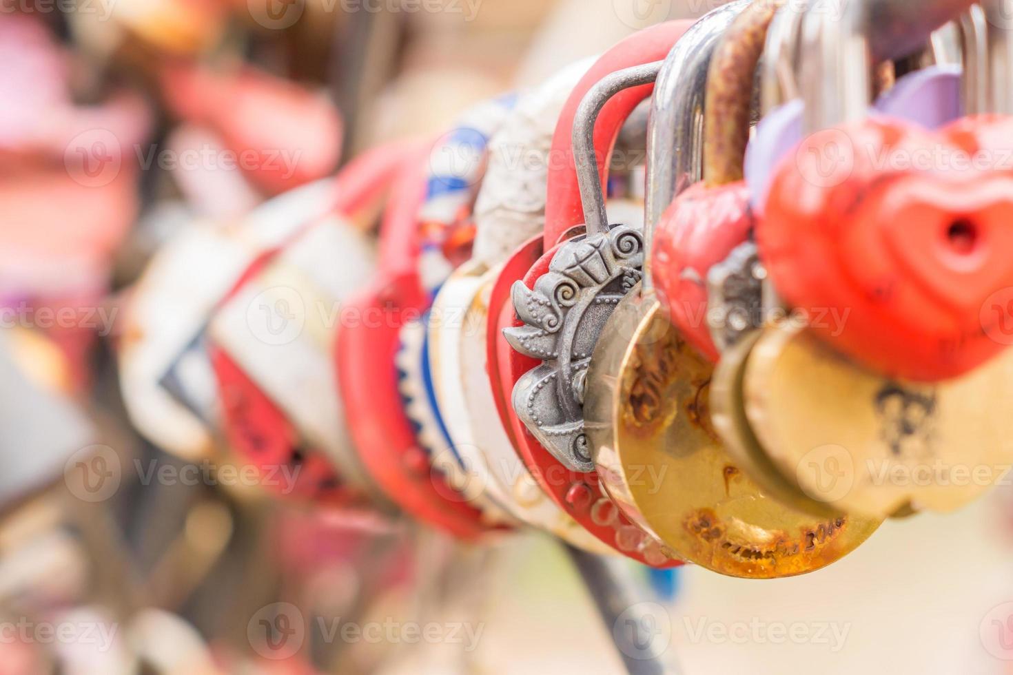 Plenty of multicolored love padlocks on metal railing of the bridge. selective focus, toned. photo