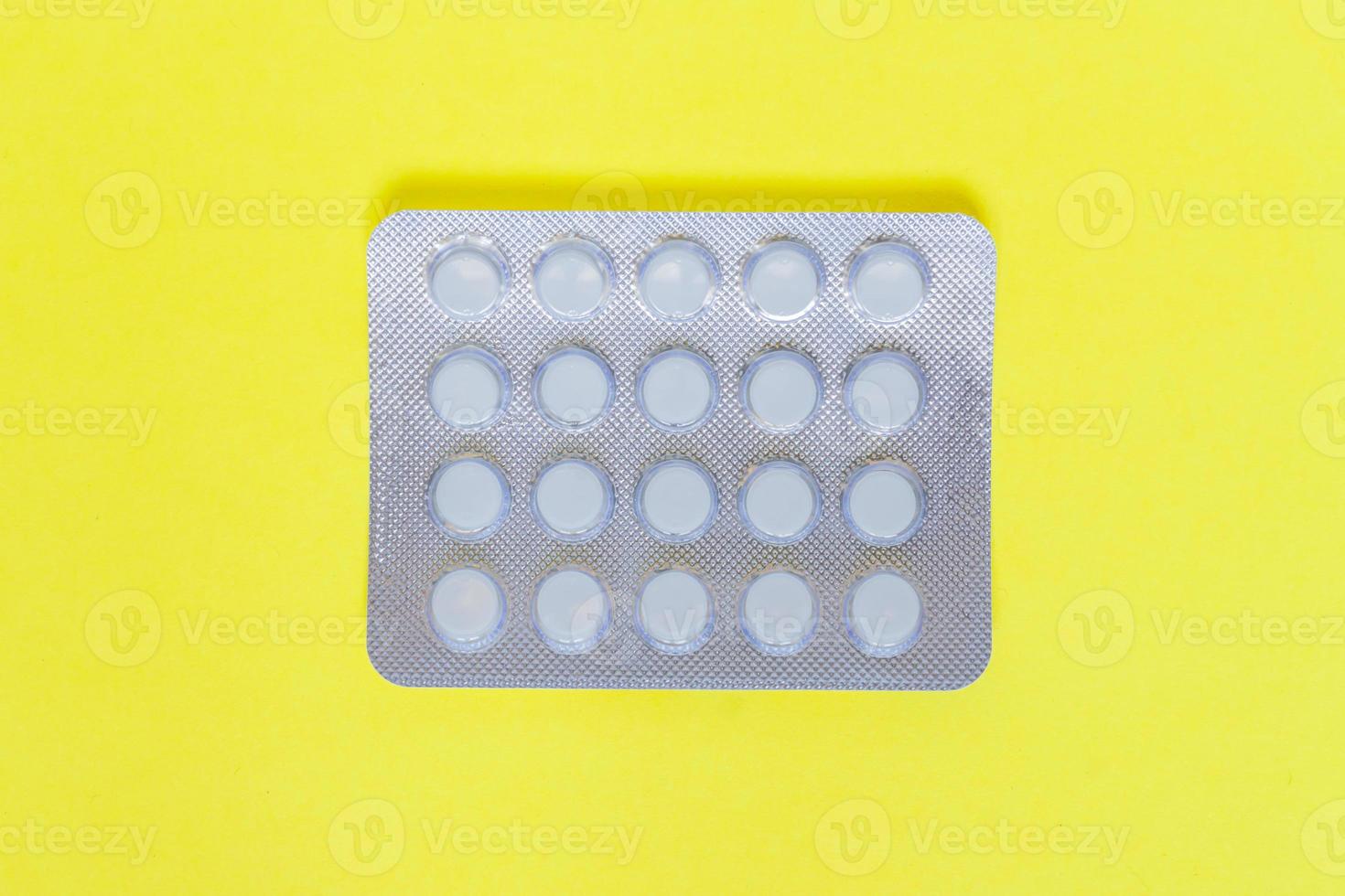 pastillas en blister sobre fondo amarillo. vista superior foto