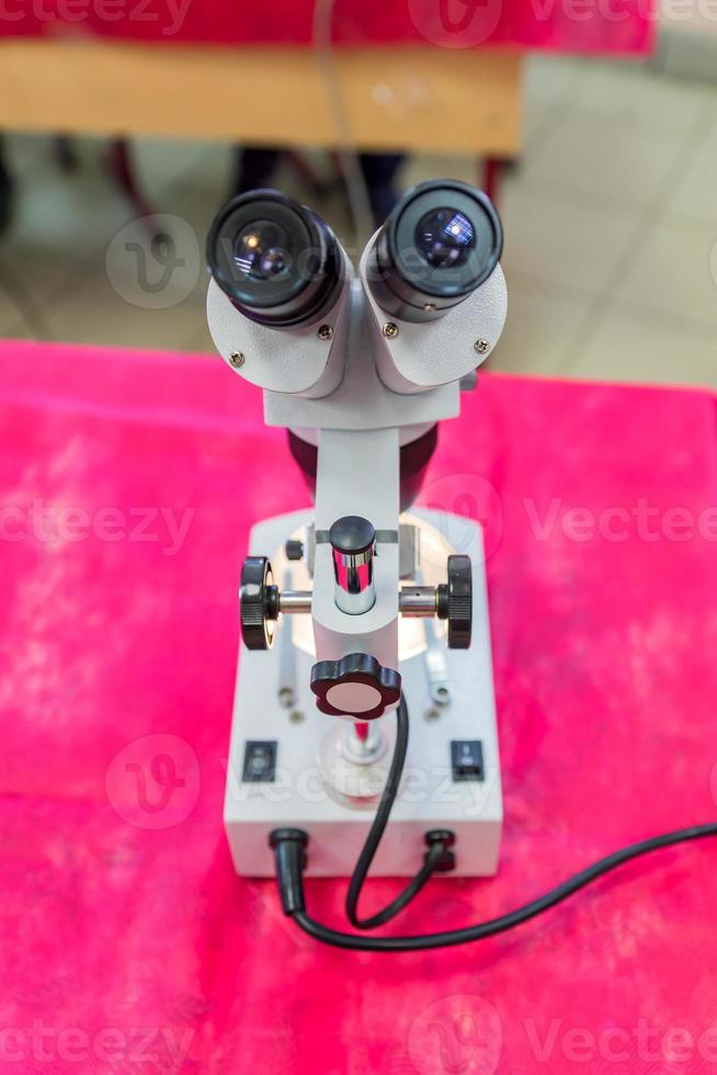 Laboratory Equipment, Optical Microscope for school lessons on red table photo