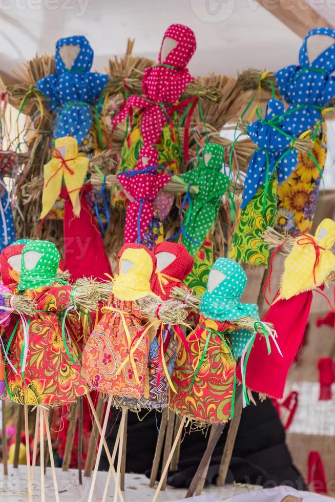 pequeñas muñecas de carnaval en la feria de la calle - espantapájaros para quemar como símbolo de la llegada de la primavera. foto