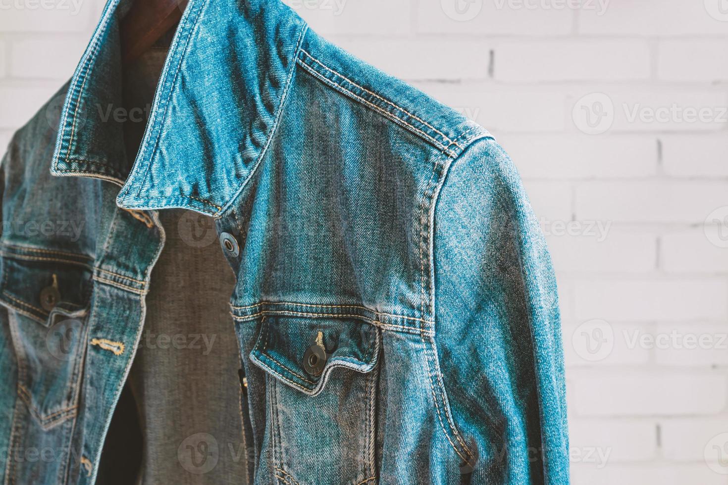 Blue denim woman jacket on a wooden hanger. Trendy clothes. photo