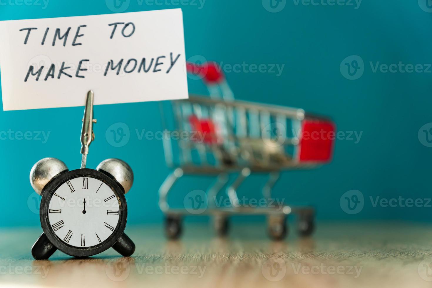 Alarm clock and banner with handwritten phrase time to make money on wooden table. buiseness concept. photo