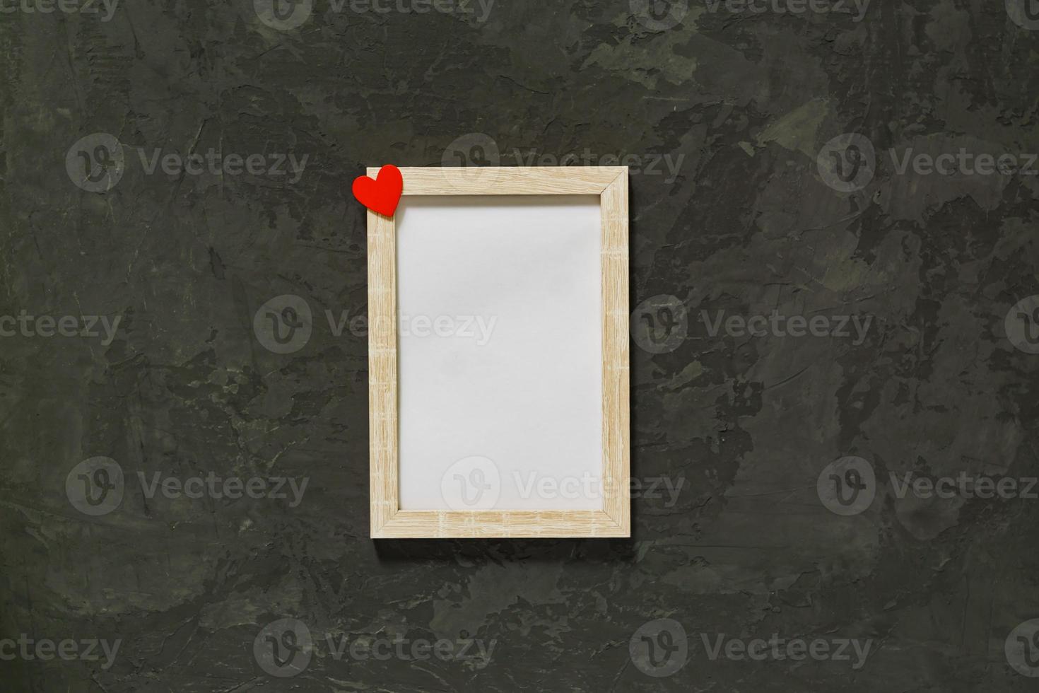 Wooden photo frame with red heart on black background. Mockup.