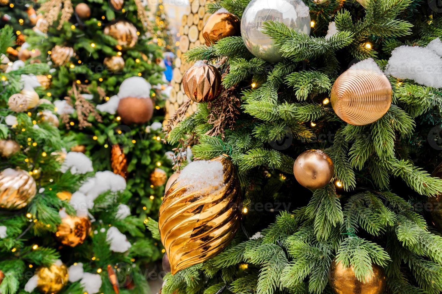 close up of christmas trees decorated with sparkling balls and garland with lights on. Festive background with copy space for your projects photo