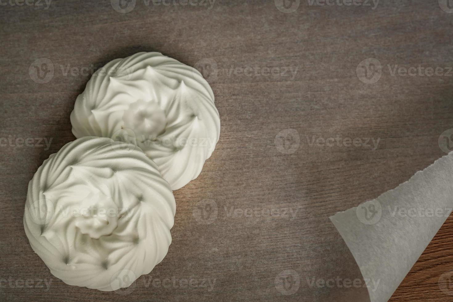 couple of meringue nests on parchment paper. top view photo