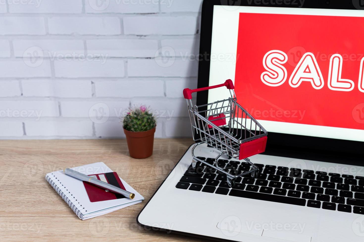 Small red shopping cart or trolley on laptop keyboard, Technology business online shopping concept photo