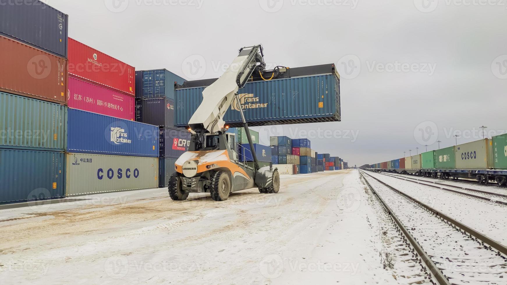 Kaluga Region, Russia, 2019 - Shipping container loading by richtracker on the freight rail car at logistic warehouse station. photo