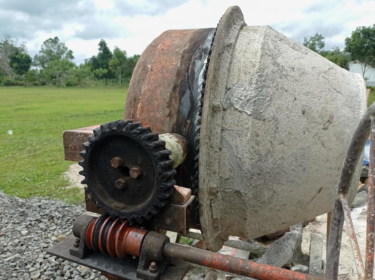 a concrete mixer installed on a construction site next to a pile of sand and gravel. photo